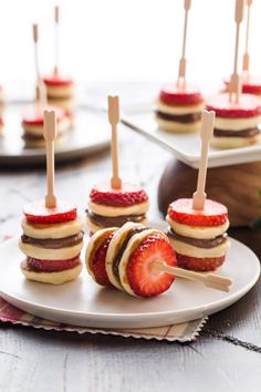 strawberries are arranged on small appetizers with toothpicks