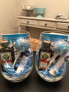 two clear vases filled with blue and white items