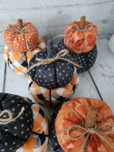 four pumpkins with black and orange designs on them, tied in twine to each other