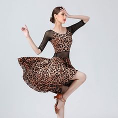 a woman in a leopard print dress is dancing