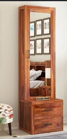 a wooden dresser sitting next to a mirror on top of a wall in a room