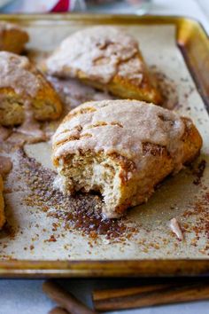 cinnamon sugar donuts on a baking tray with cinnamon sticks