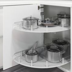 an open cabinet with pots and pans in it