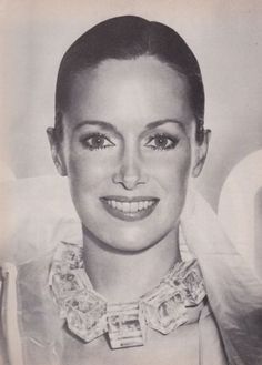 an old black and white photo of a woman with short hair wearing a collared shirt