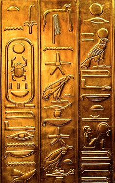 an egyptian gold hieroglyphic with symbols on it