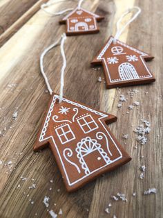 three gingerbread christmas ornaments on a wooden table