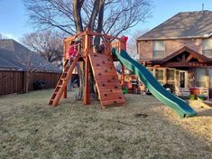 a child's play area in the backyard with a slide and climbing wall for children