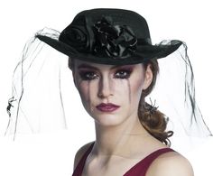 a woman wearing a black hat with flowers on it's brim and veil