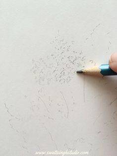 someone is drawing something on the paper with a pencil