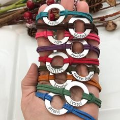 a person holding several bracelets with names on them