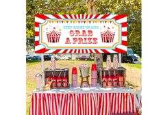 a circus themed birthday party with red and white striped table cloths, popcorn buckets, candy boxes and carnival sign