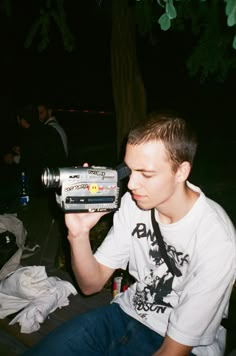 a man sitting on a bench drinking from a can