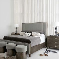 a bedroom with white walls and grey furniture