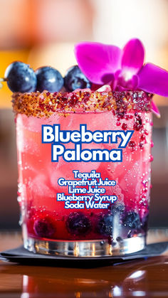 the blueberry paloma cocktail is garnished with fresh berries