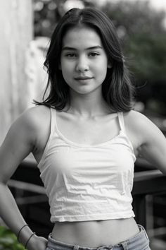 a young woman posing for a black and white photo with her hands on her hips