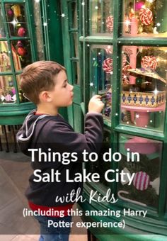 a little boy that is standing in front of a display case with christmas decorations on it