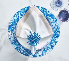 a blue and white place setting on a marble table