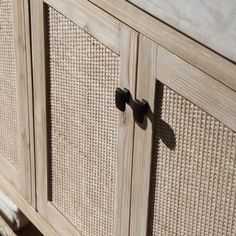 a close up of a wooden cabinet with metal handles