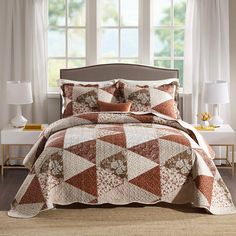 a bed in a room with white curtains and brown bedspread on top of it