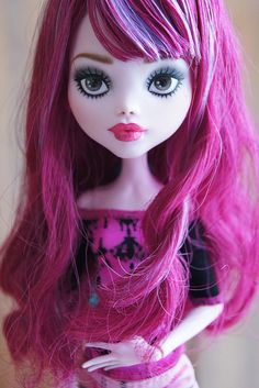 a close up of a doll with pink hair