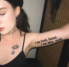 a woman with a tattoo on her arm that says i am flesh, don't stand here