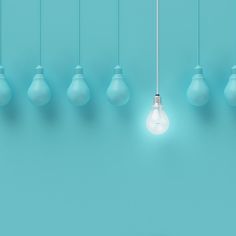 a group of light bulbs hanging from the ceiling in front of a blue wall and floor