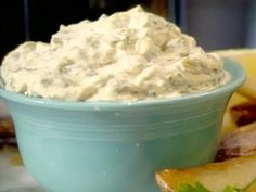 a blue bowl filled with cream cheese next to sliced bananas