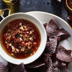 a white plate topped with a bowl of salsa and tortilla chips