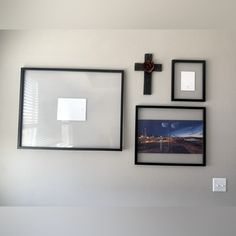 three framed pictures hang on the wall above a cross