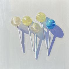 three lollipops are painted in different shades of blue, yellow and white