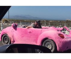 a pink car is parked on the side of the road