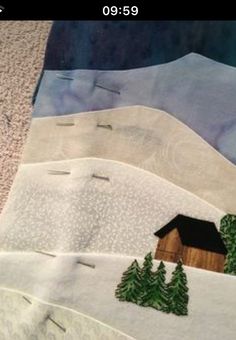 three quilts with houses and trees on them in the middle of a snowy landscape