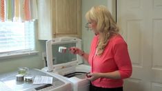 a woman standing in front of a microwave oven