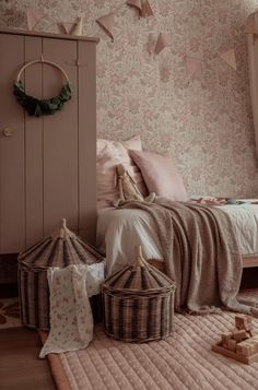 a bed room with a neatly made bed and some baskets on the floor next to it