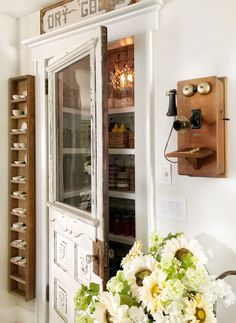 a vase filled with white flowers sitting next to a wooden door