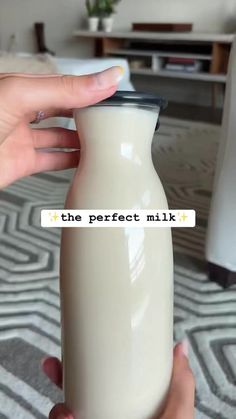 a person holding a milk bottle with the words the perfect milk on it in front of them