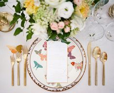 a table setting with flowers and goldware