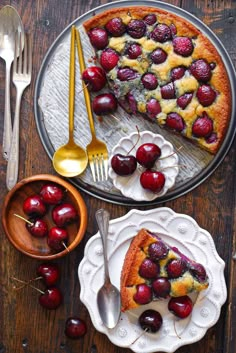 a piece of cake with cherries on it and a fork next to the pie