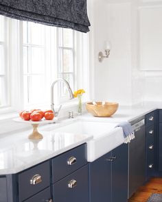 a kitchen with blue cabinets and white counter tops