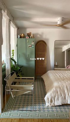 a bed sitting next to a green cabinet in a bedroom