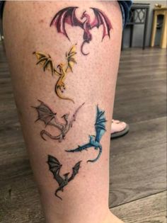 a woman's leg with tattoos on it that have different types of dragon designs