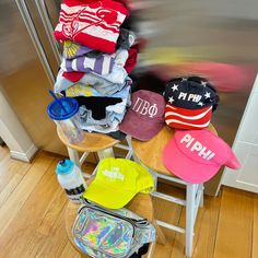 a stack of hats sitting on top of a wooden chair next to a refrigerator freezer