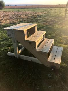 a wooden bench sitting on top of a lush green field