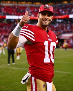 a man in a football uniform giving the thumbs up