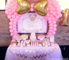 a table topped with lots of pink and gold balloons