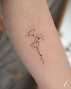 a single flower tattoo on the arm