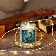 a candle that is sitting on a table next to a guitar and some string lights