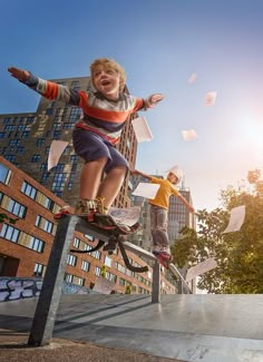 two boys on skateboards are riding down the rail with papers flying in the air