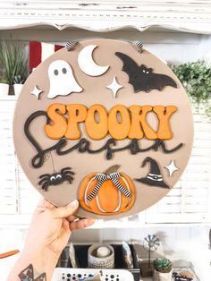 someone holding up a halloween cookie with the word spooky in front of them