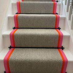 a set of stairs with pink and grey carpet